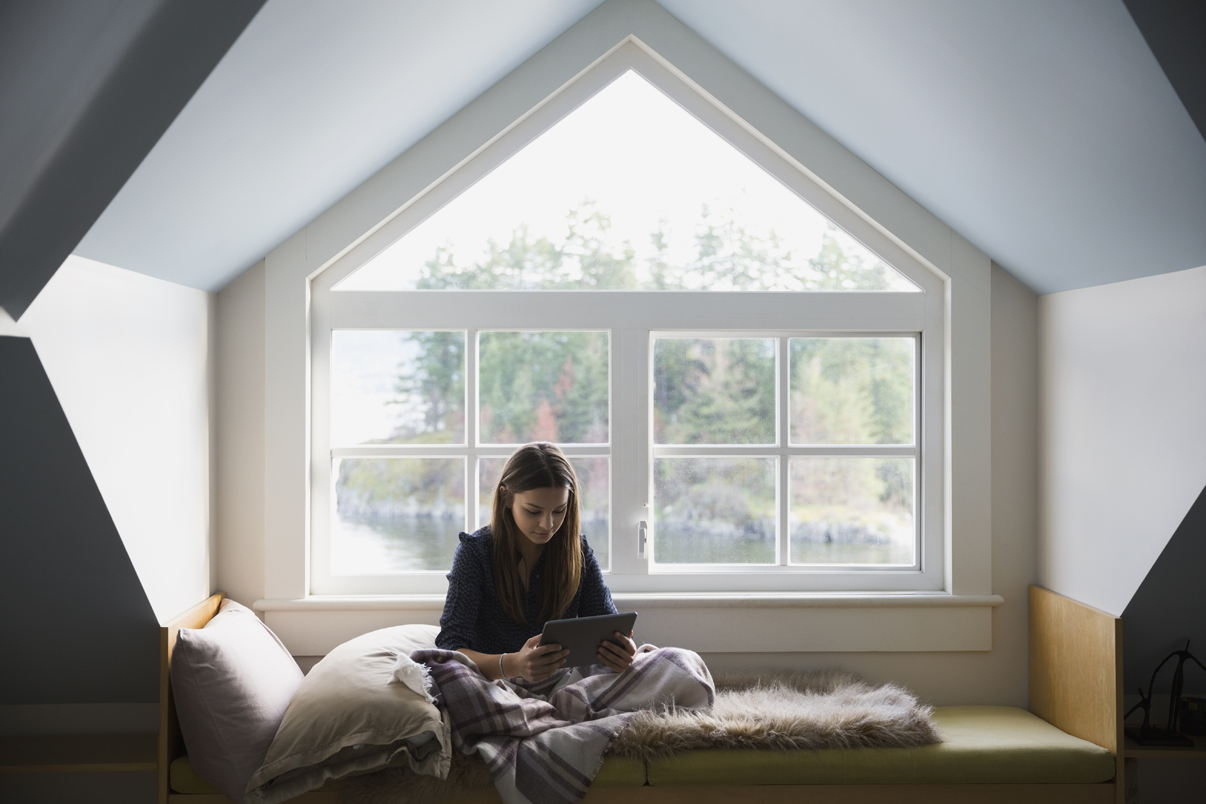 woman sitting and reading a book in her attic